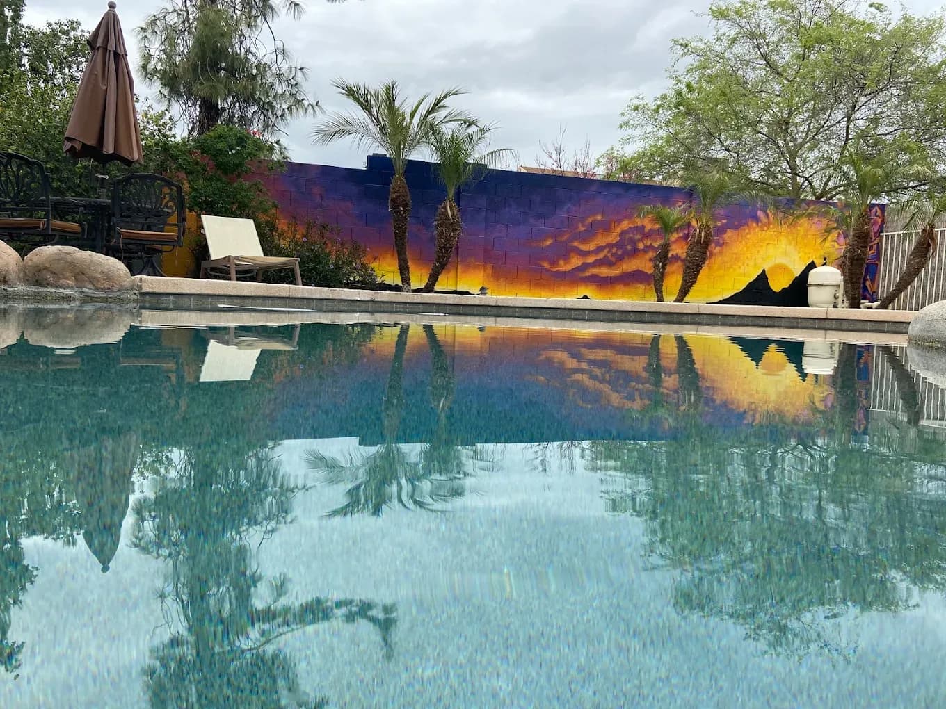 Pool reflecting sunset mural and palm trees North Phoenix