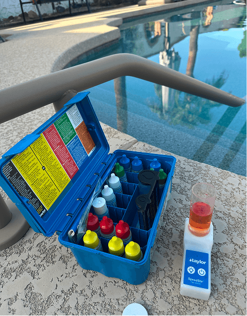 Pool water testing kit with reagents on pool deck