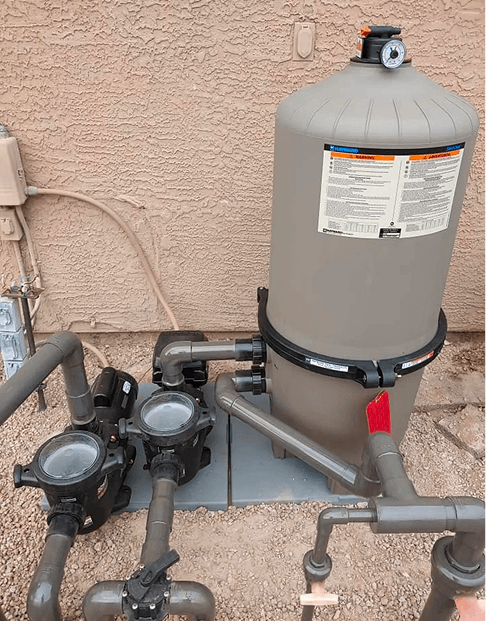 Pool filter and pump plumbing installed beside house