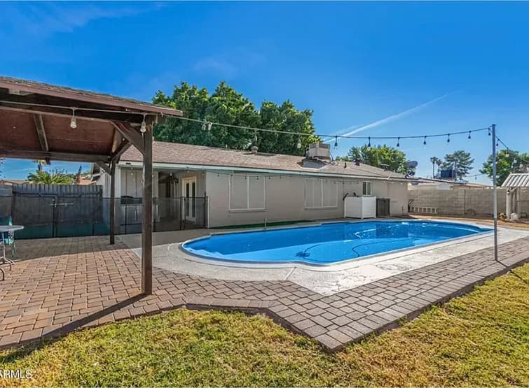 Backyard pool with paver deck pergola and string lights North Phoenix