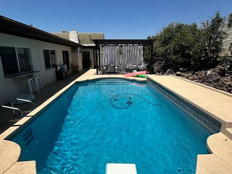 Backyard pool with patio pergola and robotic cleaner