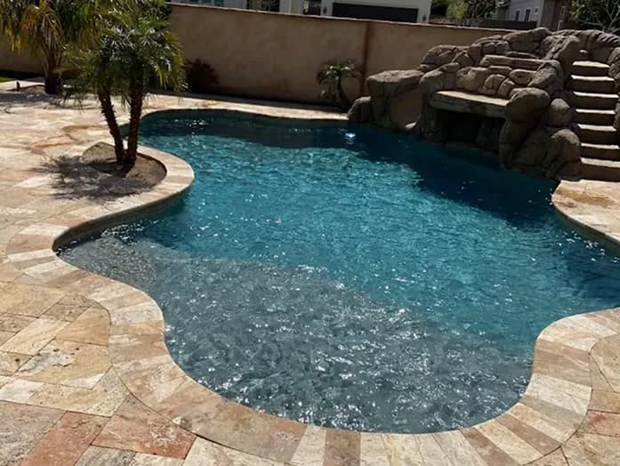 Clear pool water with desert landscaping and patio seating