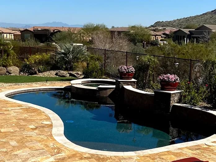 Dark pebble pool with raised spa and hilltop desert view